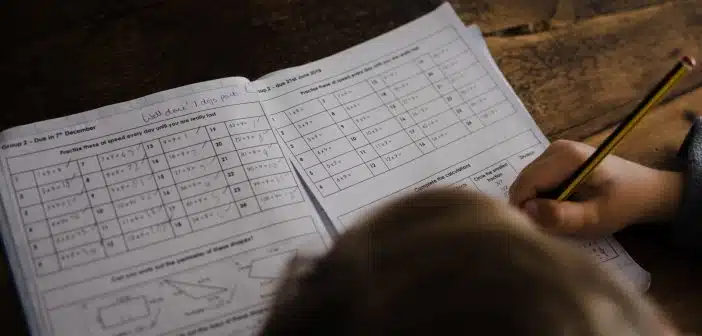 boy writes on his book on the desk